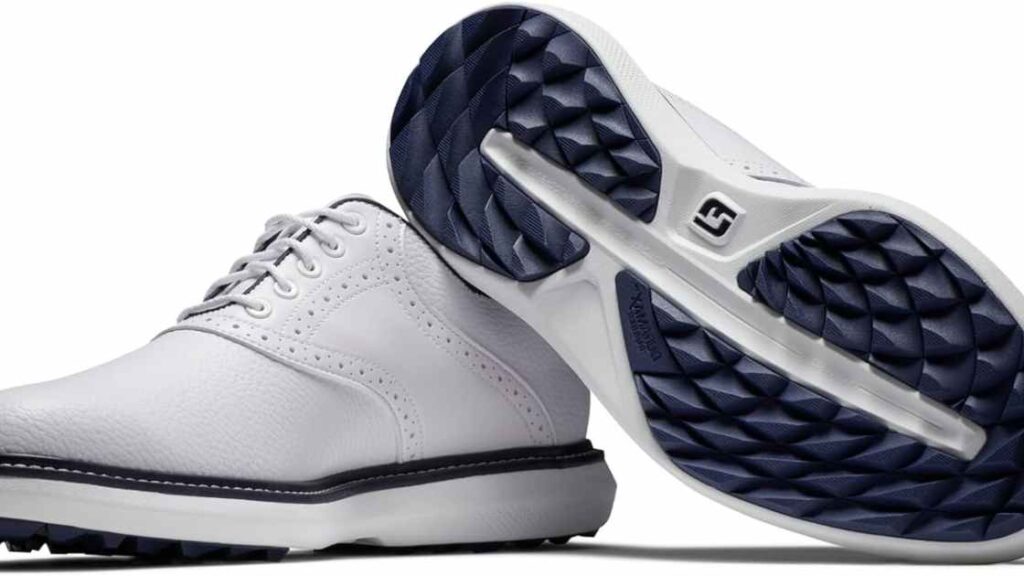 White golf shoes featuring a patterned blue sole for enhanced grip.