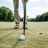 Golfer retrieving a golf ball with ease.