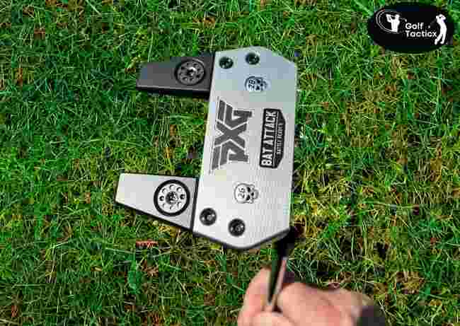 Hand holding putter grip.